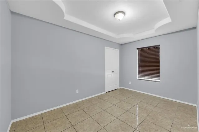 a view of an empty room with window and cabinet
