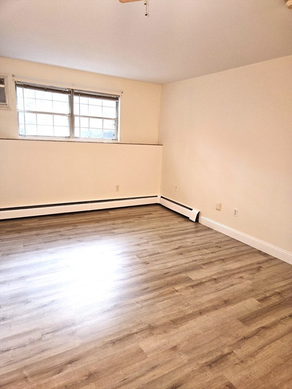 6 Venice Street, Unit F2 Danvers, MA 01923 - Photo 9 of 19 a view of empty room with wooden floor and fan