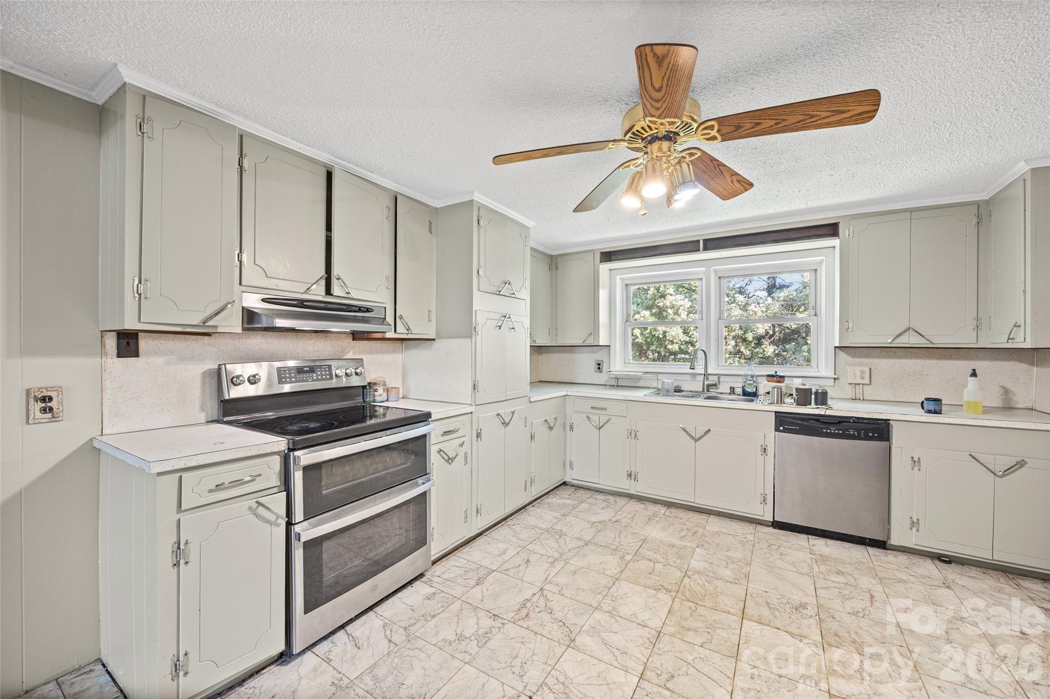 1315 Lithia Springs Road Shelby, NC 28150 - Photo 13 of 25 a kitchen with granite countertop a stove sink and dishwasher with white cabinets