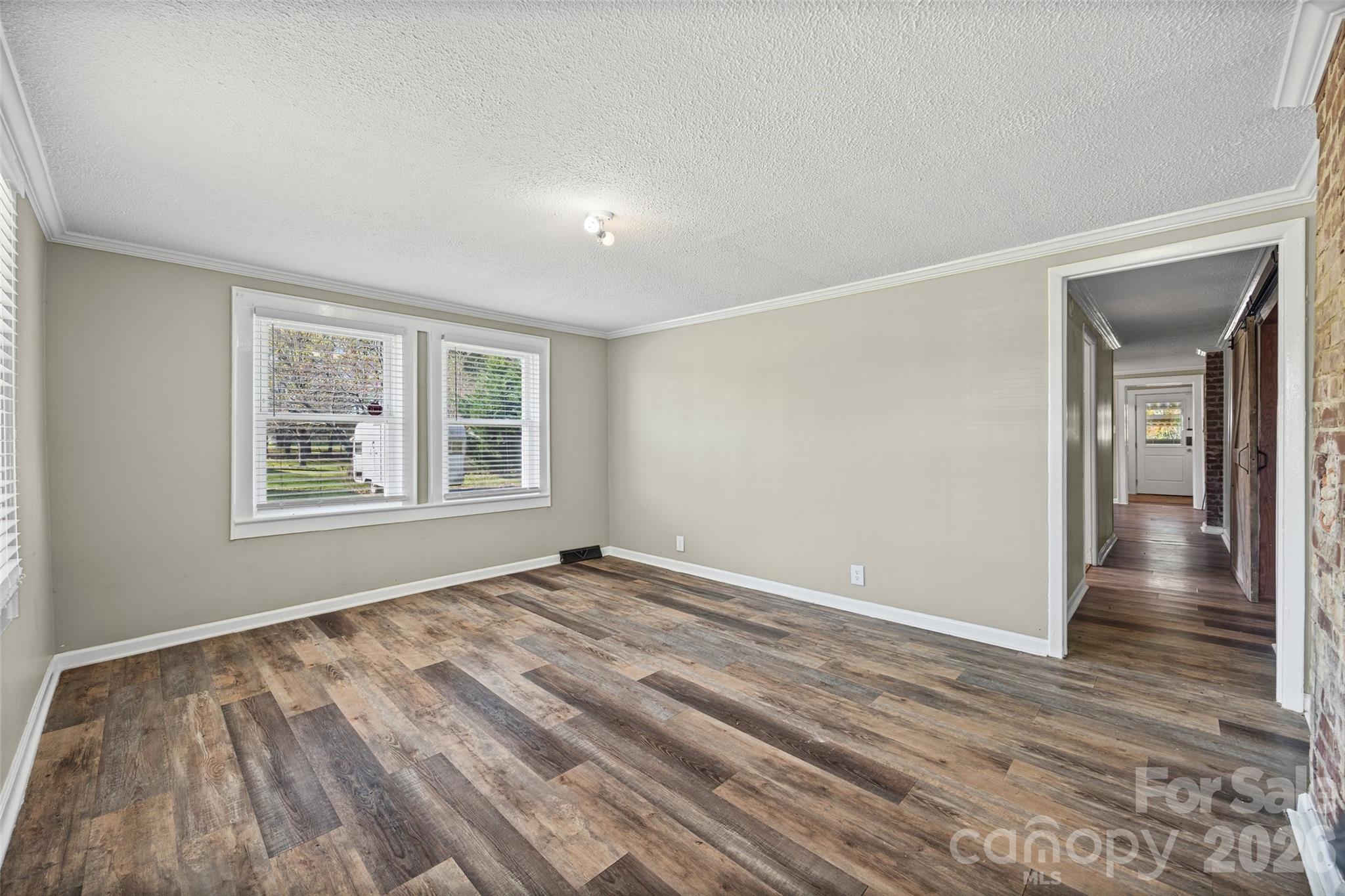 1315 Lithia Springs Road Shelby, NC 28150 - Photo 4 of 25 a view of an empty room with wooden floor and a window