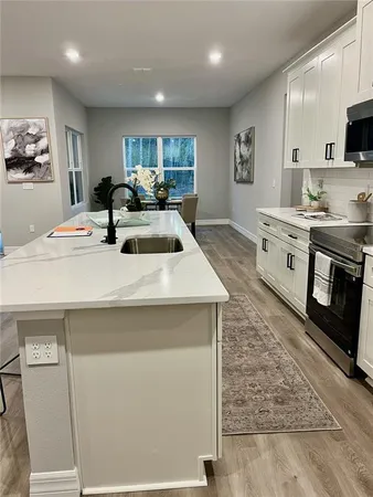 a kitchen with sink a stove and cabinets