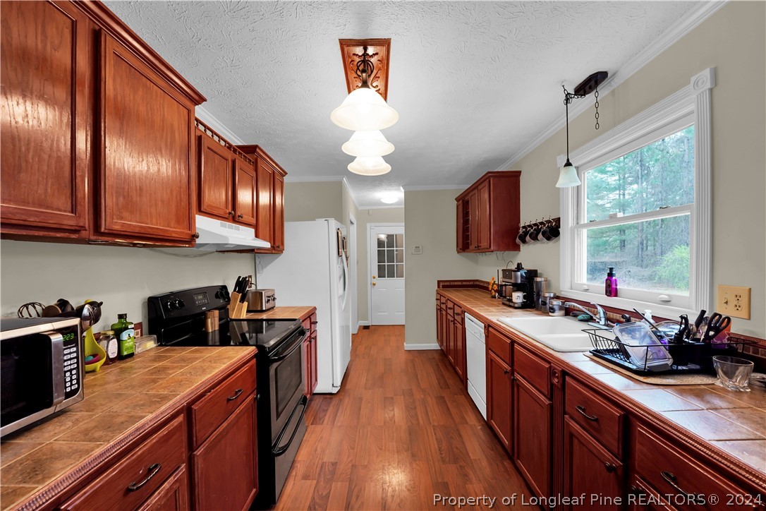480 Rockfish Road Raeford, NC 28376 - Photo 12 of 30 a kitchen with stainless steel appliances granite countertop wooden cabinets a stove top oven a sink and dishwasher