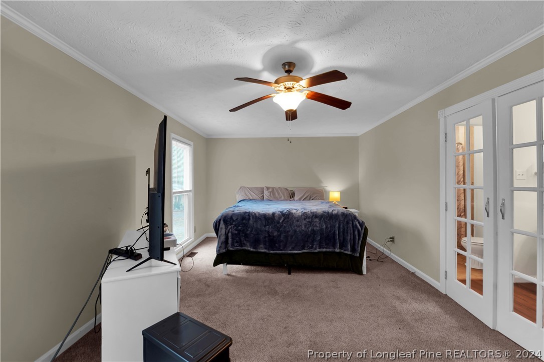 480 Rockfish Road Raeford, NC 28376 - Photo 24 of 30 a bedroom with a bed and a chandelier