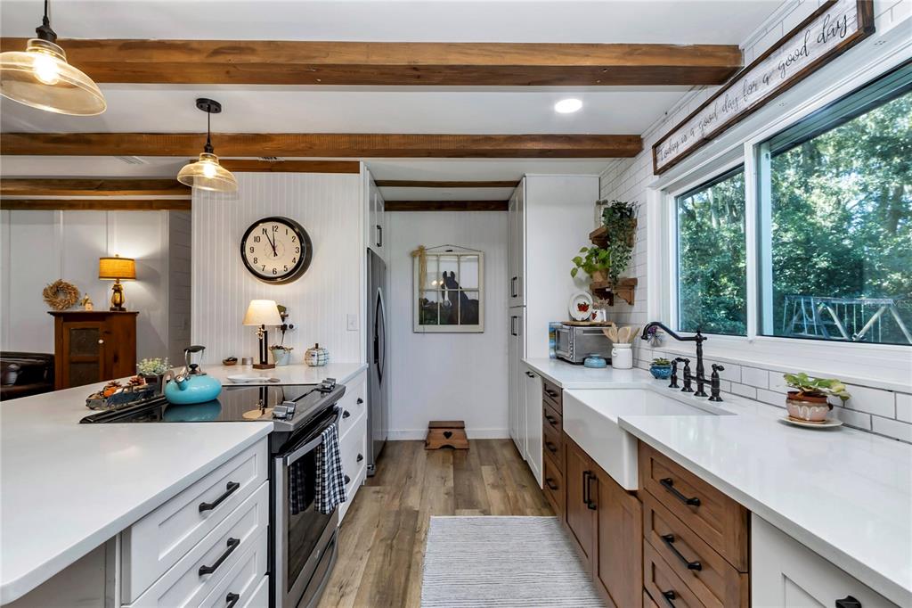 13232 Northeast 39th Terrace Anthony, FL 32617 - Photo 13 of 55 a kitchen with a large window and a clock on the wall