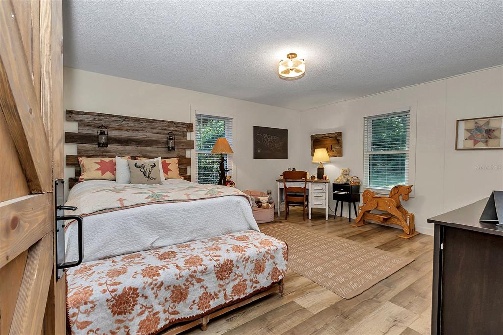 13232 Northeast 39th Terrace Anthony, FL 32617 - Photo 25 of 55 a bedroom with a bed and wooden floor