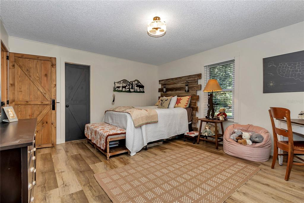 13232 Northeast 39th Terrace Anthony, FL 32617 - Photo 26 of 55 a bedroom with a bed and a chair in it