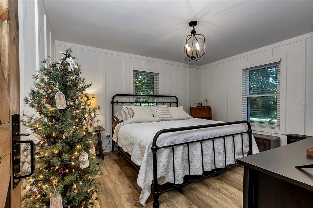 13232 Northeast 39th Terrace Anthony, FL 32617 - Photo 27 of 55 a bedroom with a bed and a chandelier