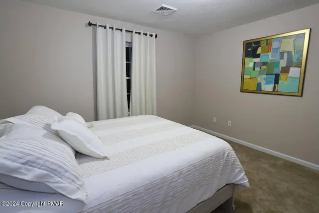 a bedroom with a bed and painting on the wall
