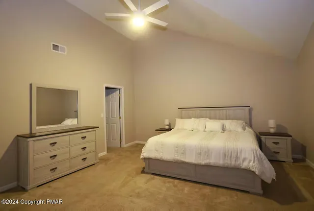 a bedroom with a bed and dresser with mirror