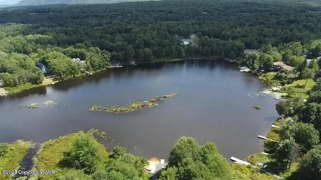 an aerial view of a house with a yard and lake view