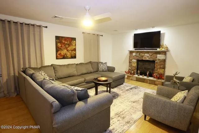 a living room with furniture a flat screen tv and a fireplace
