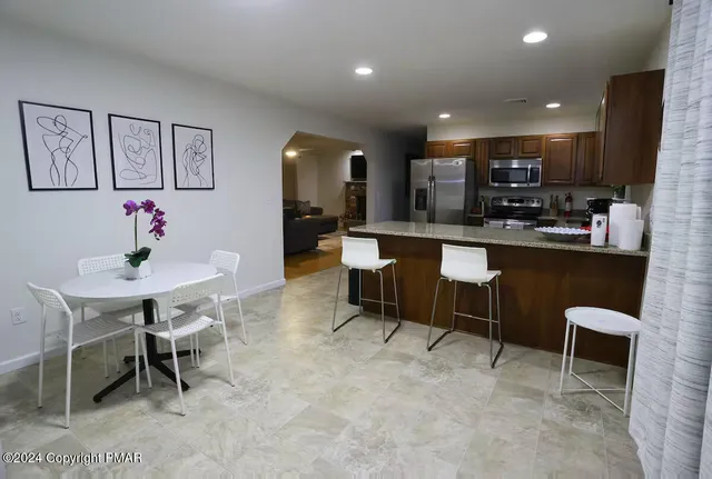 a kitchen with a dining table chairs and sink