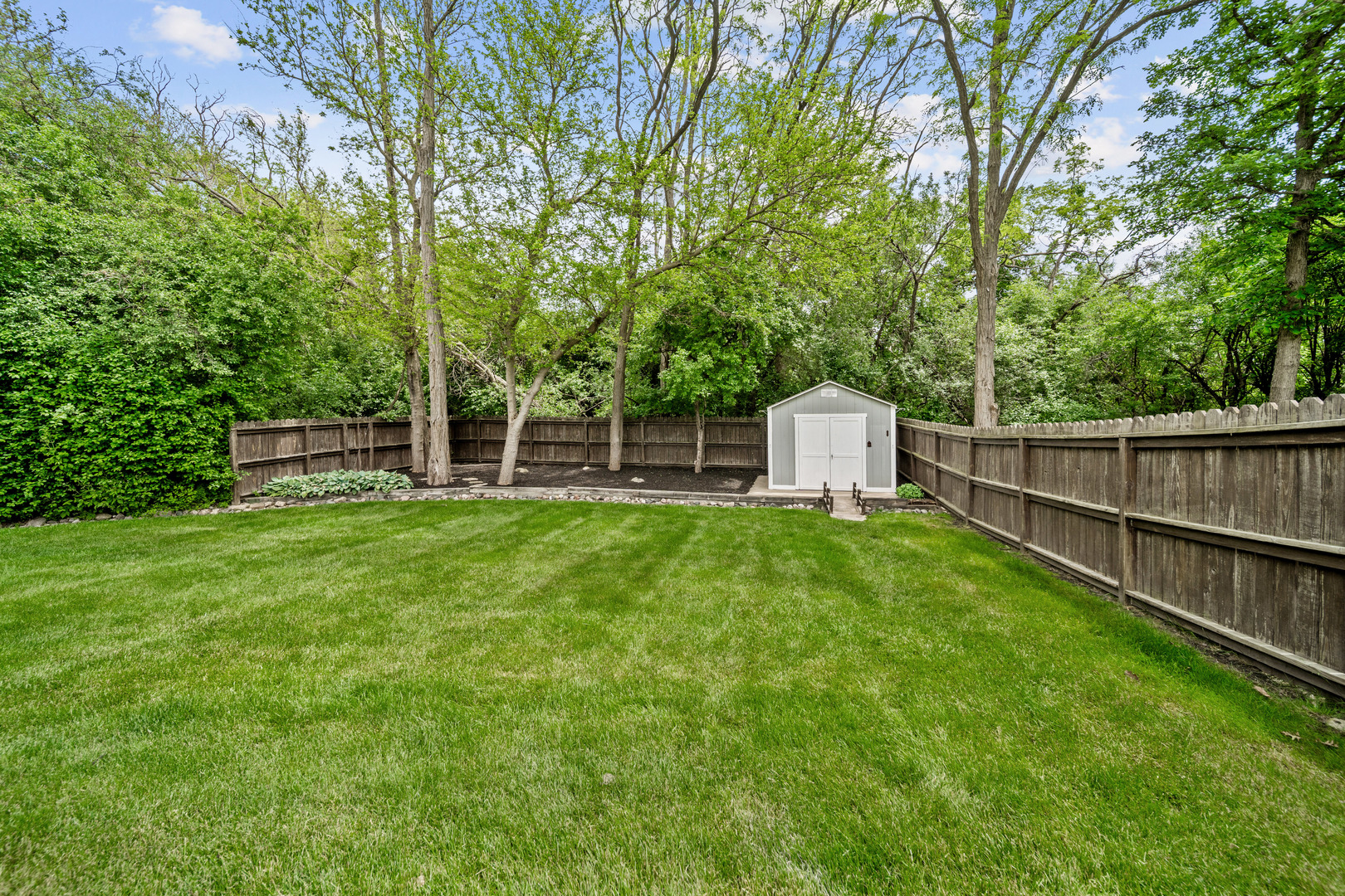 28W140 Mack Road Wheaton, IL 60189 - Photo 48 of 48 a view of a backyard with table and chairs and wooden fence