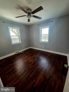 en empty room with wooden floor and windows