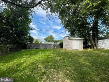 a view of a house with a yard and a large tree