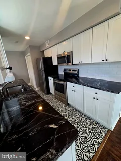 a kitchen with granite countertop a stove and a sink