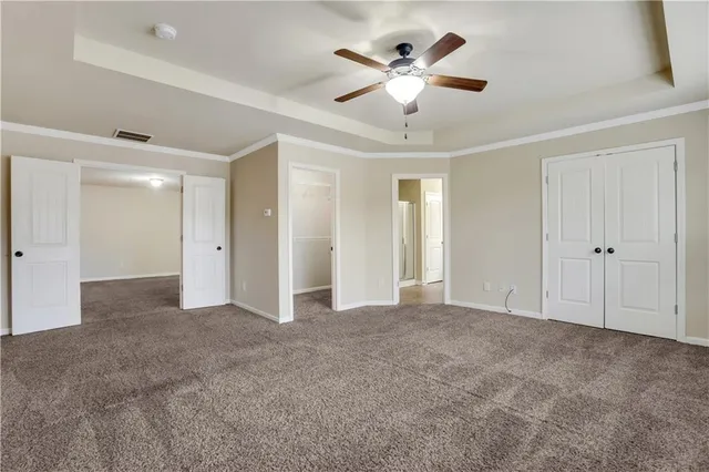 a view of an empty room with a chandelier fan