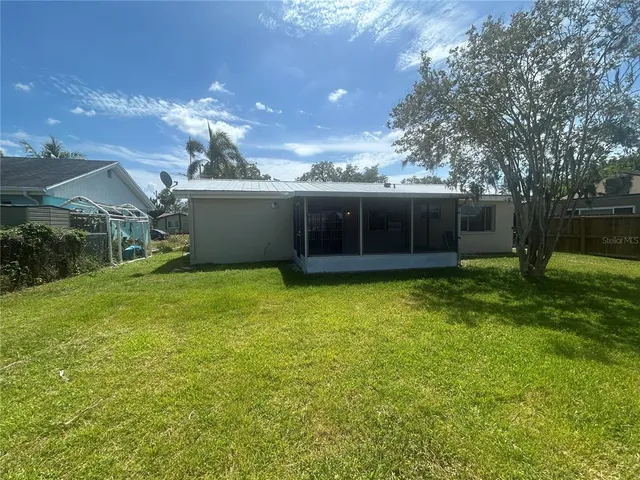 a view of a house with a backyard and a tree