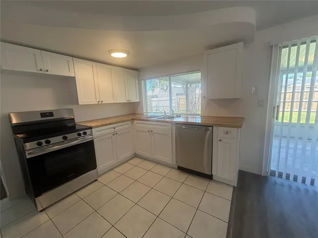 a kitchen with a stove sink and cabinets