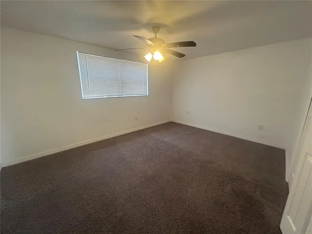 a view of an empty room with a chandelier fan