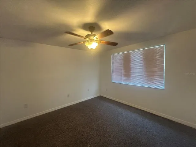 a view of room with a ceiling fan and window