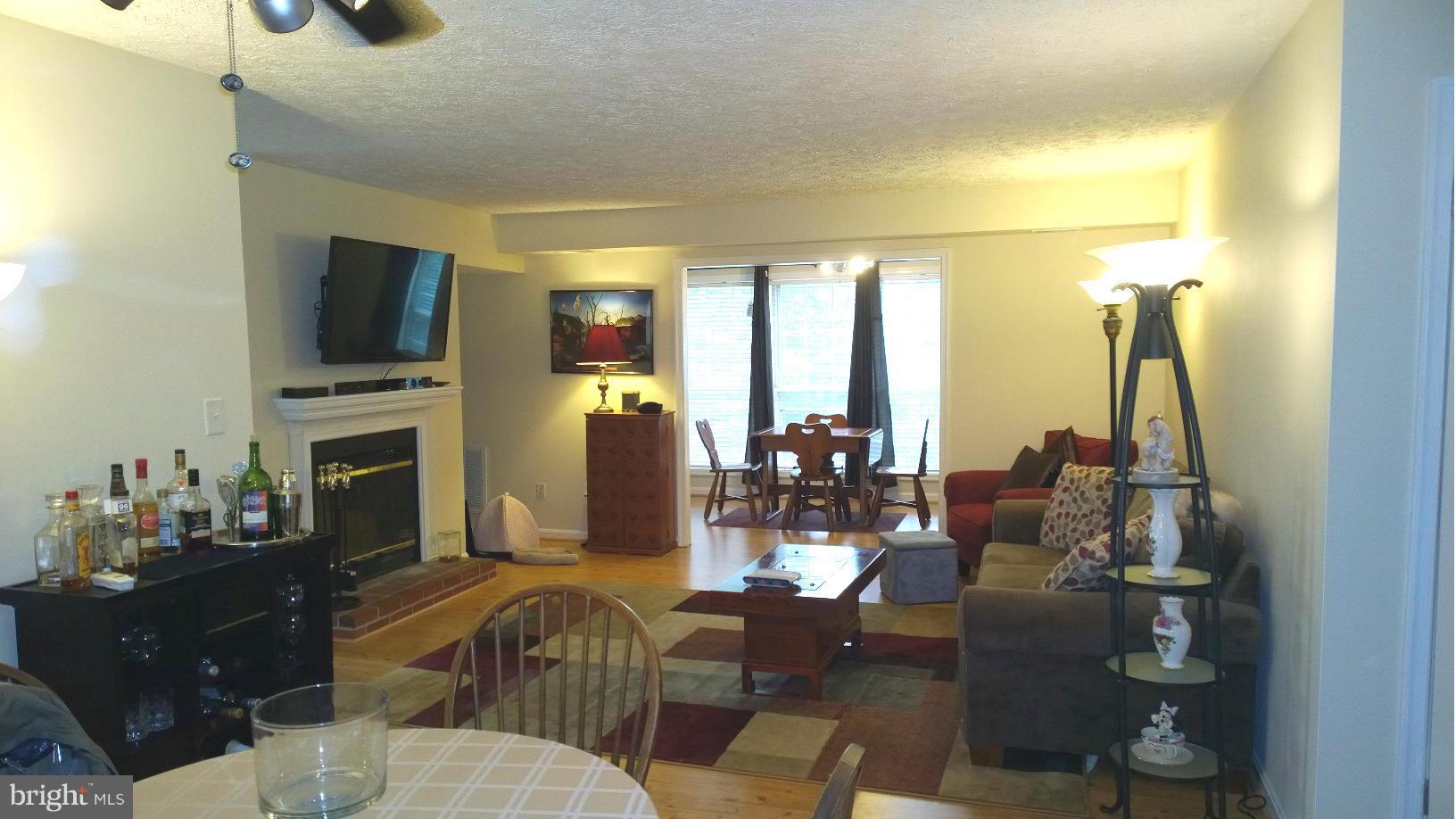 9927 Oakton Terrace Road, Unit 9927 Oakton, VA 22124 - Photo 11 of 19 a living room with fireplace furniture and a flat screen tv