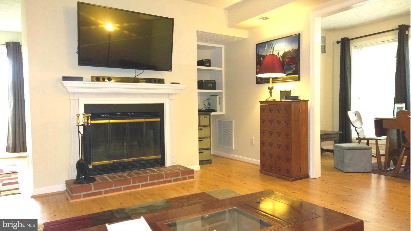 9927 Oakton Terrace Road, Unit 9927 Oakton, VA 22124 - Photo 13 of 19 a living room with a flat screen tv and a fireplace