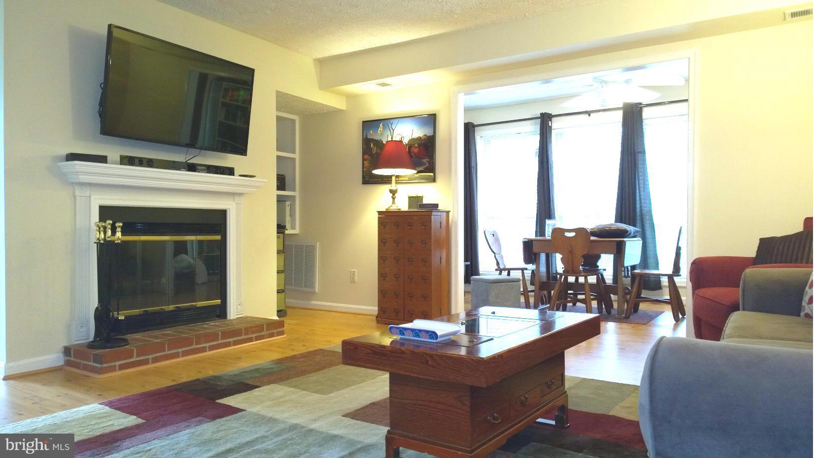 9927 Oakton Terrace Road, Unit 9927 Oakton, VA 22124 - Photo 14 of 19 a living room with fireplace furniture and a flat screen tv