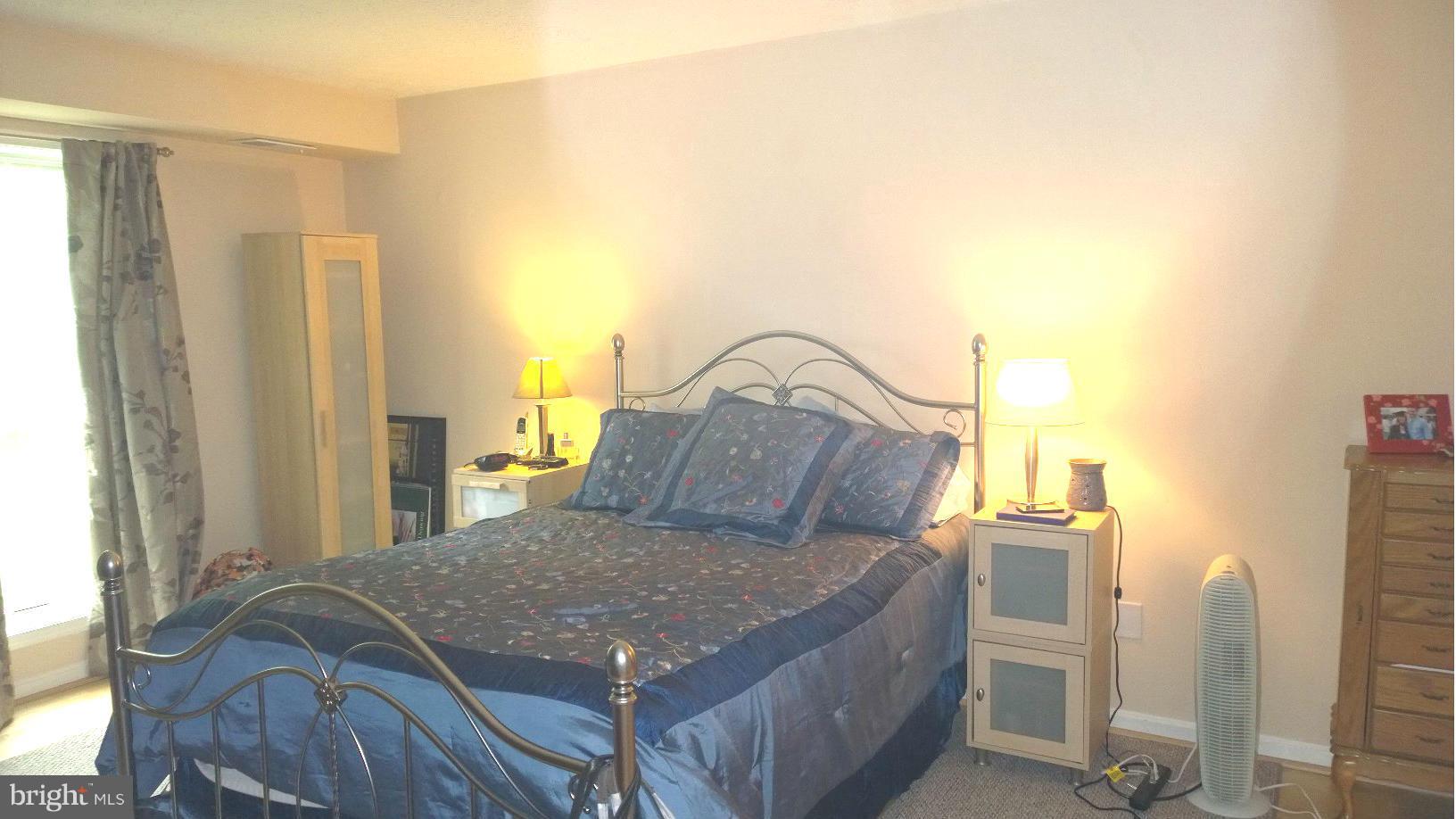 9927 Oakton Terrace Road, Unit 9927 Oakton, VA 22124 - Photo 16 of 19 a bedroom with a large bed and a chandelier