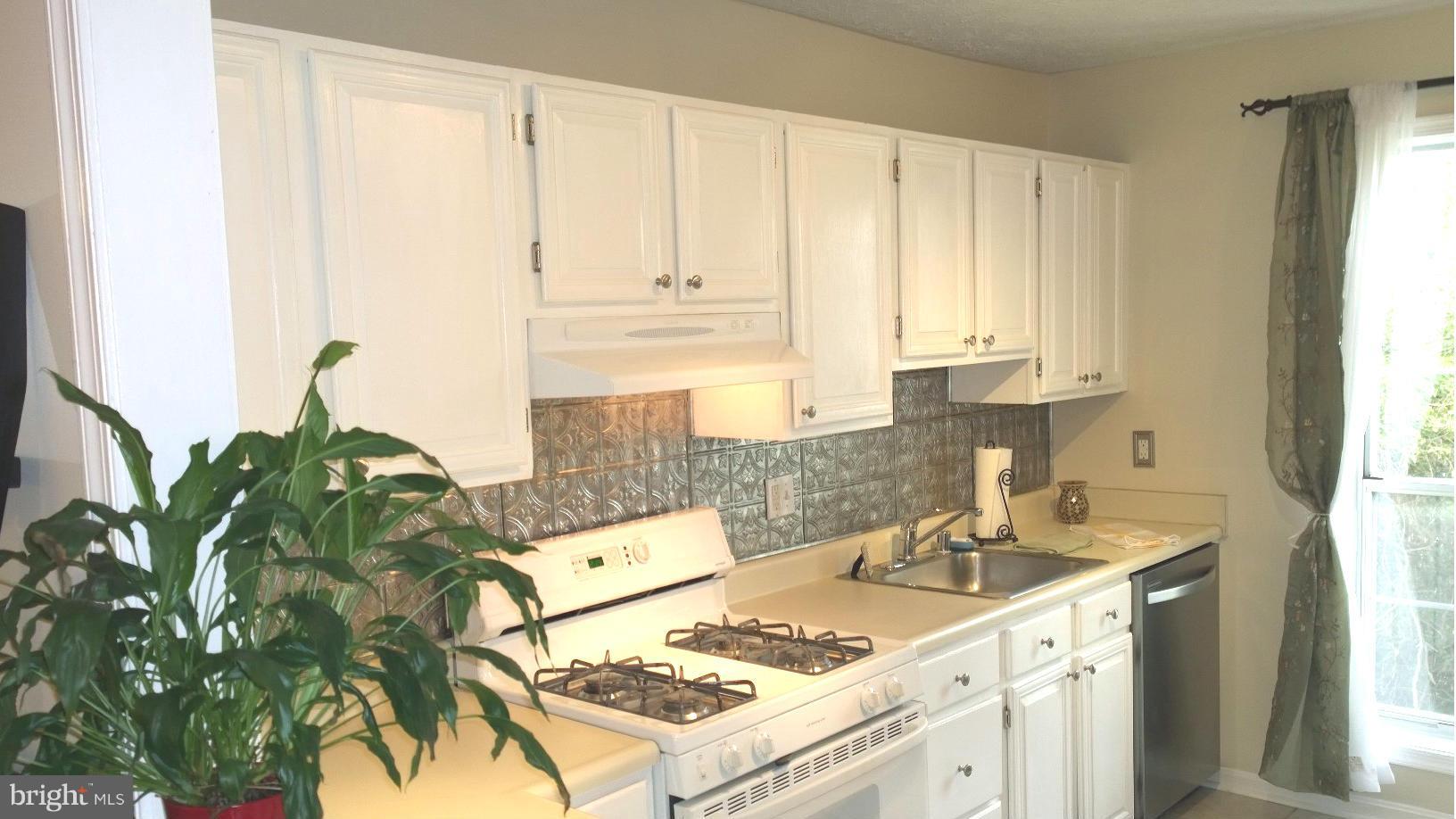9927 Oakton Terrace Road, Unit 9927 Oakton, VA 22124 - Photo 6 of 19 a kitchen with stainless steel appliances granite countertop a sink stove and cabinets