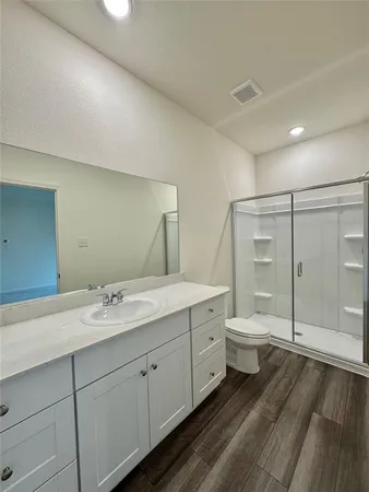 a spacious bathroom with a double vanity sink toilet and shower