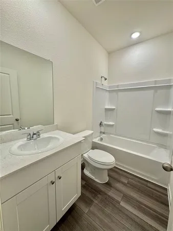 a bathroom with a double vanity sink toilet and a tub