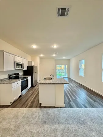 a large kitchen with a stove a sink and a refrigerator