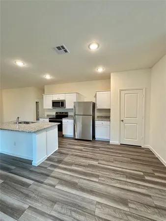 a large kitchen with stainless steel appliances kitchen island a large counter top and oven