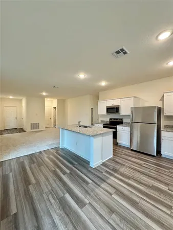 a large kitchen with a refrigerator and a stove top oven
