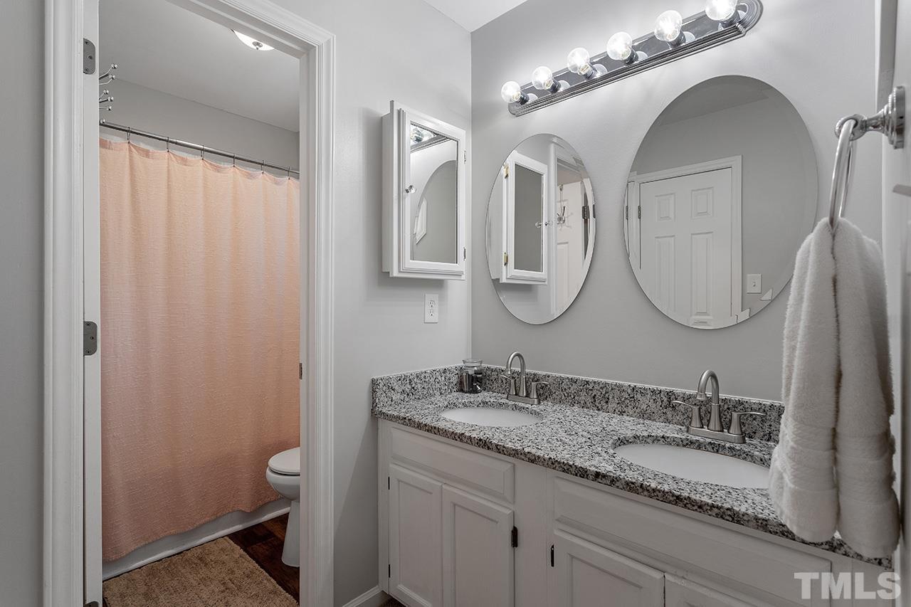 4433 Labrador Drive Raleigh, NC 27616 - Photo 18 of 30 a bathroom with a granite countertop double vanity sink and a mirror