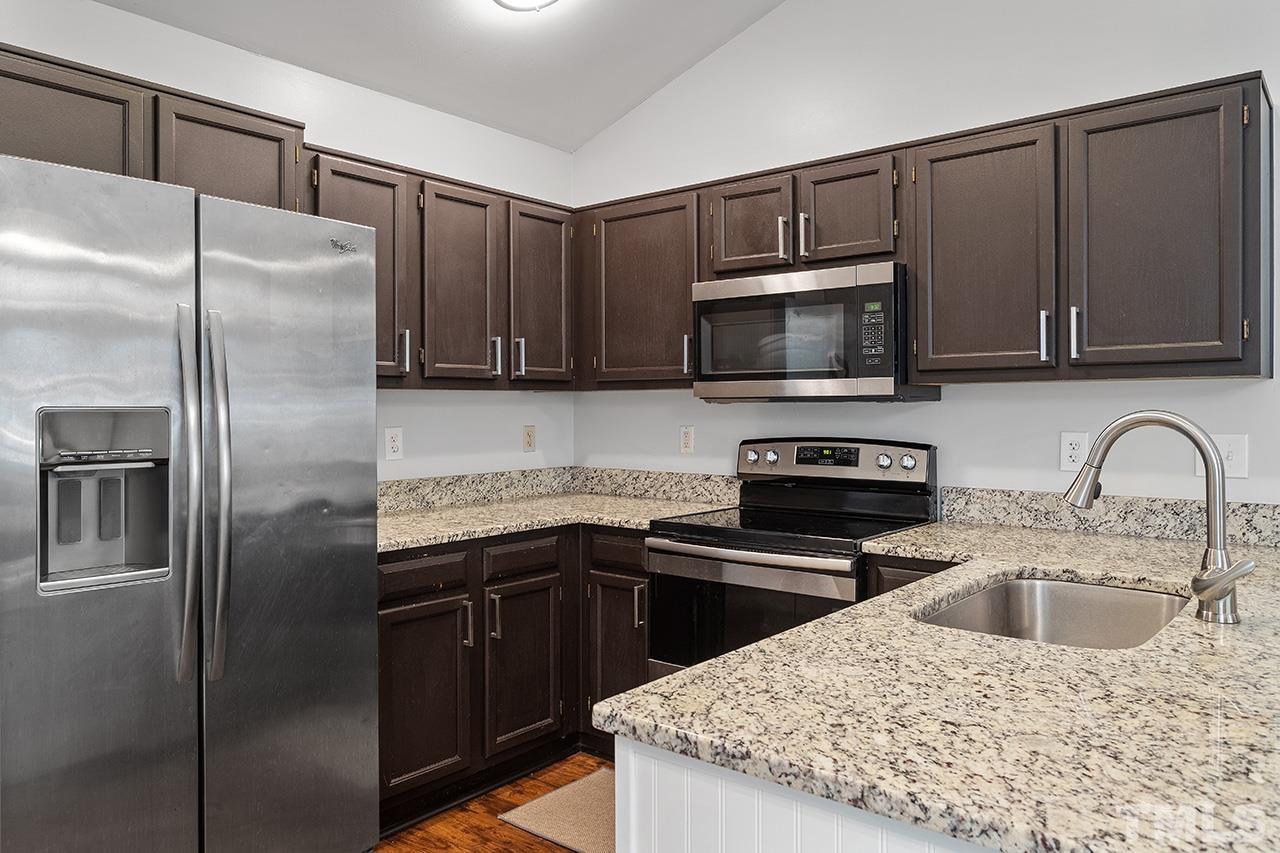 4433 Labrador Drive Raleigh, NC 27616 - Photo 3 of 30 a kitchen with a sink a microwave a refrigerator and cabinets