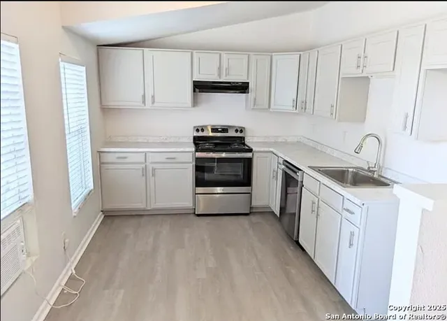 a kitchen with a sink stove and cabinets