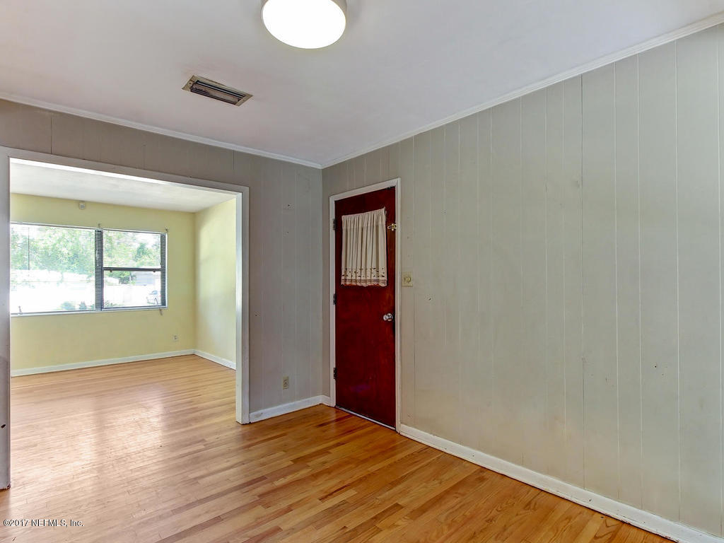 3755 Rogero Road Jacksonville, FL 32277 - Photo 12 of 32 an empty room with wooden floor and windows
