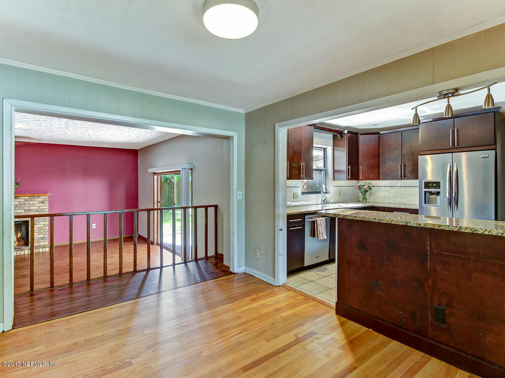3755 Rogero Road Jacksonville, FL 32277 - Photo 7 of 32 a kitchen with stainless steel appliances granite countertop a refrigerator a sink dishwasher a stove with wooden cabinets and floor
