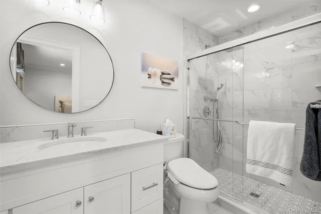 a bathroom with a sink a toilet and a mirror