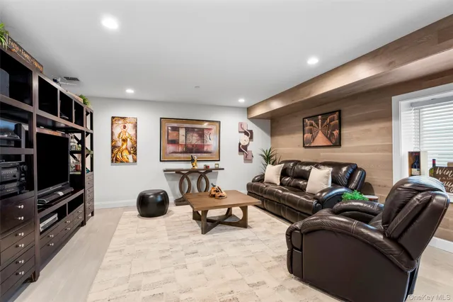 a living room with furniture a flat screen tv and gym equipment