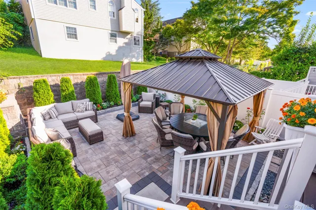 a view of a patio with couches table and chairs with wooden fence and plants