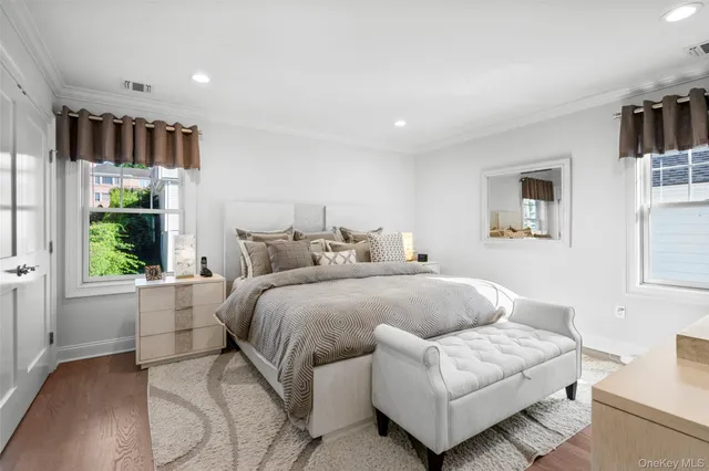 a spacious bedroom with a bed a couch and a window