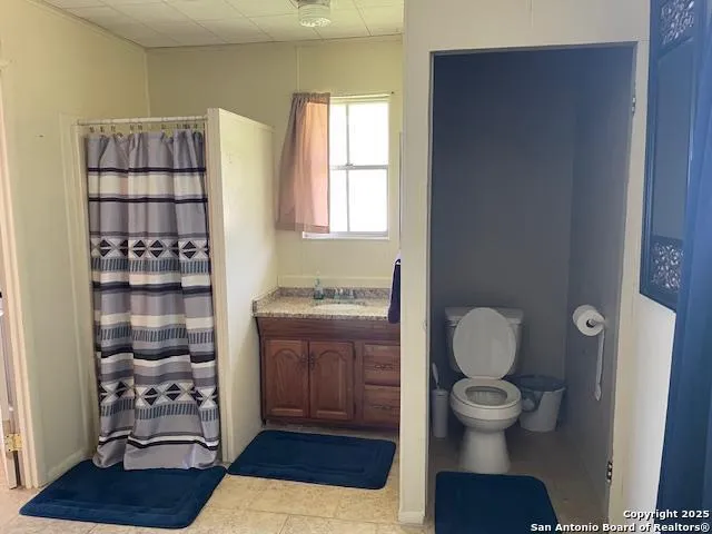 a bathroom with a toilet a sink and a window