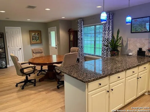 a kitchen with granite countertop kitchen island dining table and chairs