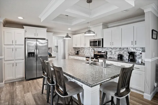 a kitchen with kitchen island a refrigerator stove microwave and cabinets