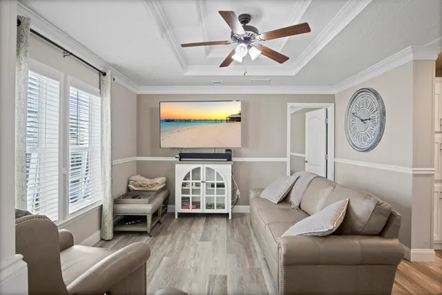 a living room with furniture a clock tv and a window