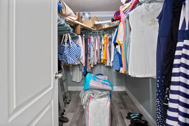 a view of walk in closet with clothes and shoes