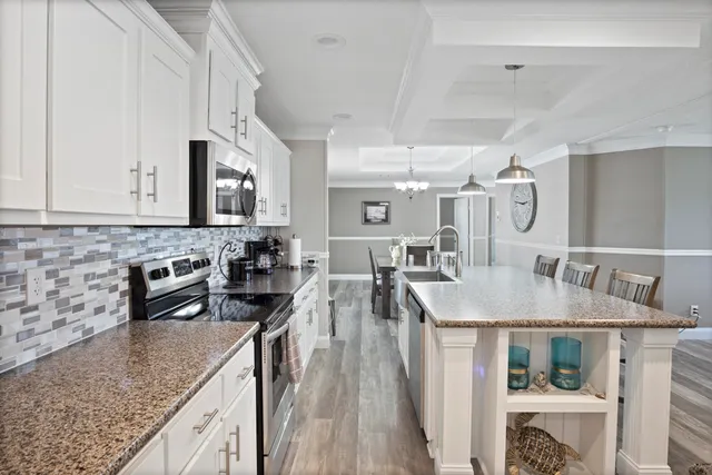 a kitchen with stainless steel appliances granite countertop a sink a stove and a wooden cabinets